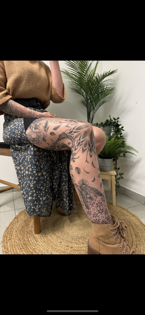 A large-scale tattoo on a leg by Carlo from Carlo Tattoo. It features soft-shaded floral blooms on the thigh and a detailed sea turtle surrounded by flowers on the lower leg, all integrated with geometric dotwork patterns.