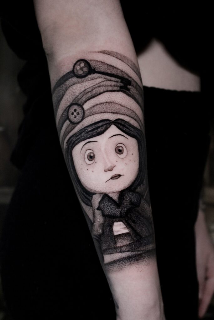 Een prachtige illustratieve black and grey tattoo van het personage Coraline op een onderarm. Het ontwerp bevat Coraline met haar kenmerkende sproetjes en een dromerige blik, omringd door symbolische elementen zoals knopen en de sleutel. Vakmanschap van Jana (Jana Jacques Tattoo) op de Sint-Niklaas Tattoo Expo.