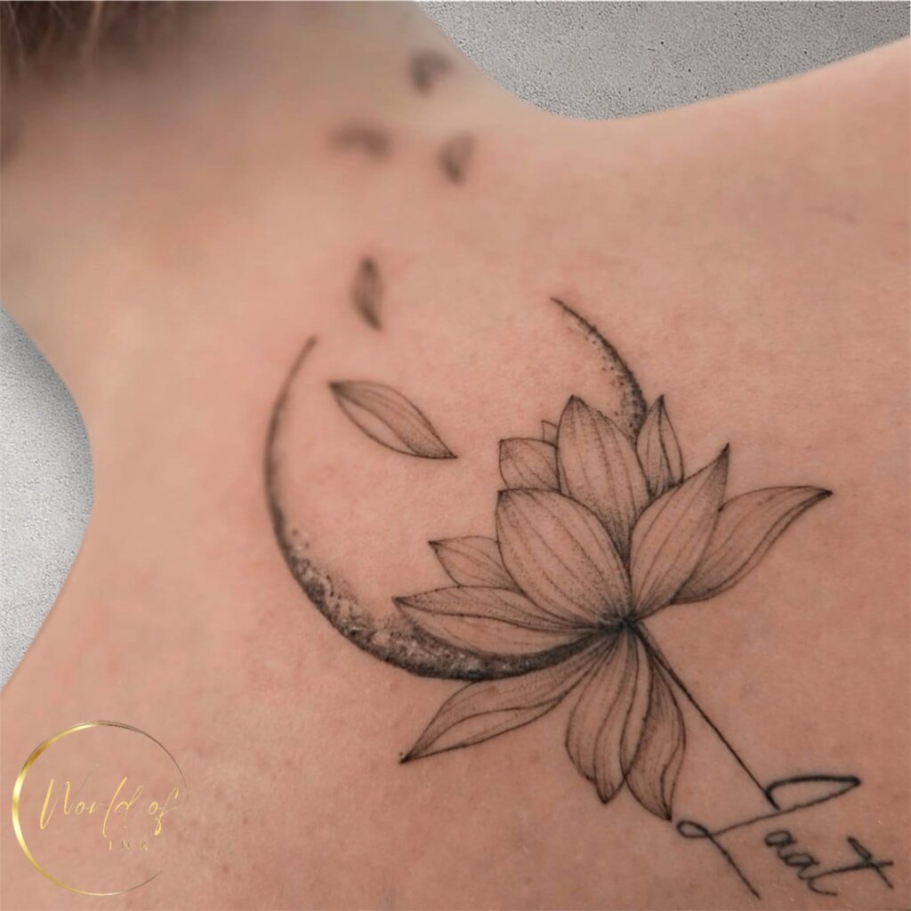 Een artistieke fineline tattoo op de schouder/nek van een gedetailleerde lotusbloem die gecombineerd is met een halve maan in dotwork-stijl. Enkele bloemblaadjes lijken weg te waaien en onderaan staat het woord Laat in een vloeiend handschrift. Werk van Angelika (Go Ink Tattoos) op de Sint-Niklaas Tattoo Expo.